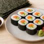 Sliced sushi rolls wrapped in dark nori seaweed with colourful fillings, served with soy sauce, wasabi and pickled ginger.